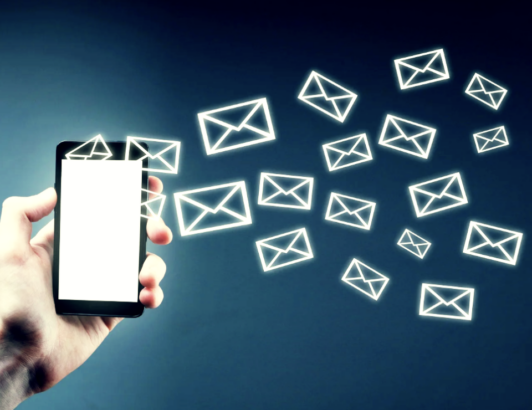 Hand holding smartphone with glowing email icons floating outward, representing email and digital communication.